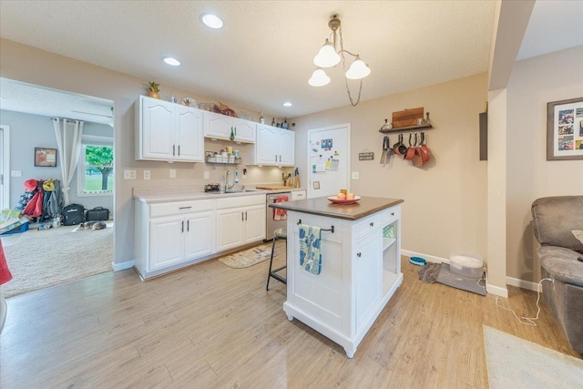 505 Tamula Dr, Mahomet, IL 61853 - kitchen with white cabinetry, light wood finished floors, open shelves, dishwasher, and a kitchen island