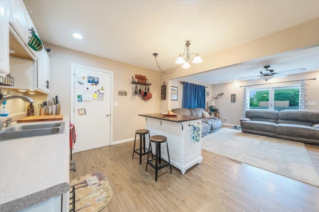 505 Tamula Dr, Mahomet, IL 61853 - kitchen with a kitchen breakfast bar, white cabinets, open floor plan, light wood-type flooring, and recessed lighting