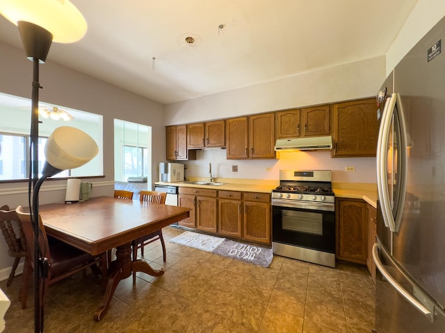 962 Harvest Cir, Buffalo Grove, IL 60089 - kitchen with appliances with stainless steel finishes, under cabinet range hood, brown cabinetry, and light countertops