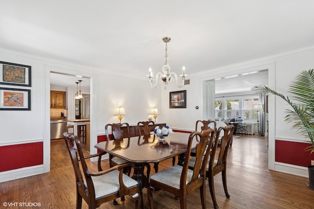 311 Wagner Rd, Northfield, IL 60093 - dining area featuring wood finished floors, a chandelier, and crown molding