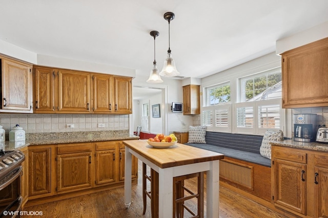 311 Wagner Rd, Northfield, IL 60093 - kitchen with electric stove, dark wood-type flooring, backsplash, brown cabinetry, and decorative light fixtures