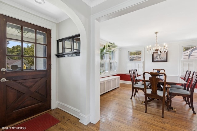 311 Wagner Rd, Northfield, IL 60093 - entrance foyer featuring radiator, wood finished floors, a chandelier, ornamental molding, and arched walkways