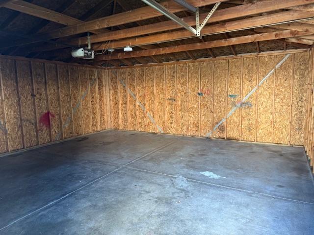 1023 N Elmwood Ave, Waukegan, IL 60085 - garage featuring a garage door opener and wood walls