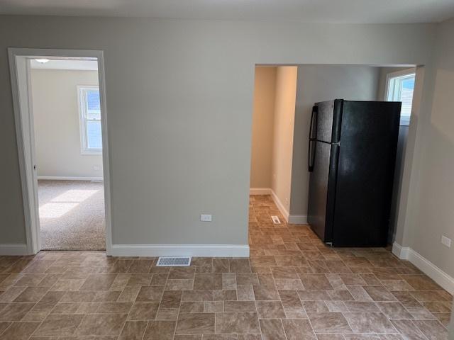1023 N Elmwood Ave, Waukegan, IL 60085 - kitchen featuring freestanding refrigerator and baseboards