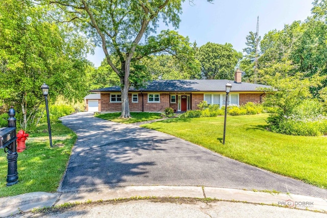 16 Yorkshire Dr, Lincolnshire, IL 60069 - ranch-style home with a chimney, brick siding, a front lawn, a garage, and driveway