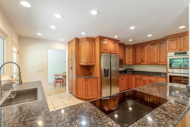 16 Yorkshire Dr, Lincolnshire, IL 60069 - kitchen with stainless steel appliances, recessed lighting, brown cabinetry, light tile patterned floors, and dark stone counters