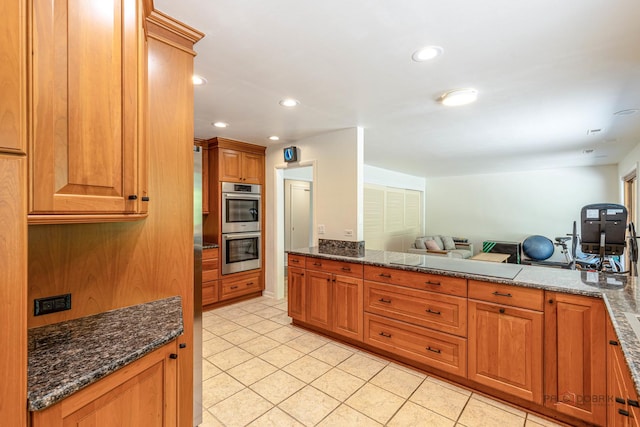 16 Yorkshire Dr, Lincolnshire, IL 60069 - kitchen with double oven, light tile patterned floors, open floor plan, brown cabinetry, and dark stone counters