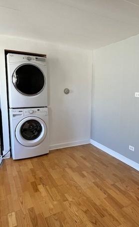 5209 S Leclaire Ave Unit 3B, Chicago, IL 60638 - washroom with stacked washer and clothes dryer and light wood finished floors