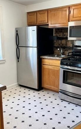 5209 S Leclaire Ave Unit 3B, Chicago, IL 60638 - kitchen featuring appliances with stainless steel finishes, tasteful backsplash, brown cabinetry, and light floors