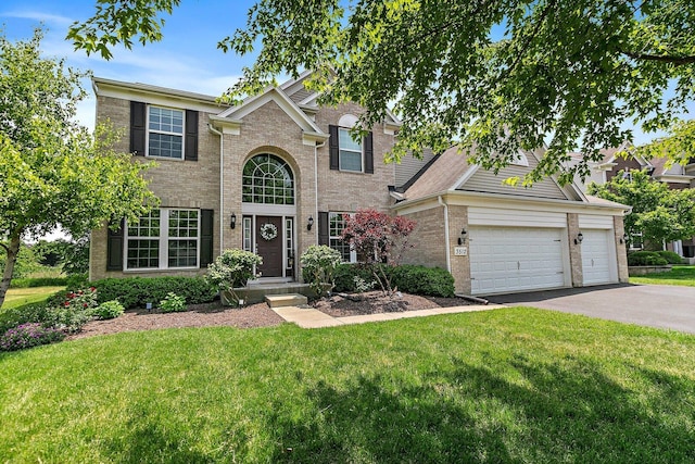 3512 Chancery Ln, Carpentersville, IL 60110 - traditional-style house with brick siding, a front yard, driveway, and a garage