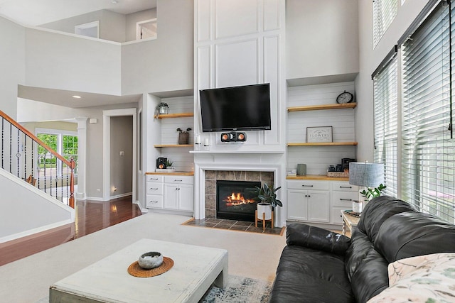 3512 Chancery Ln, Carpentersville, IL 60110 - living room featuring a tiled fireplace, stairway, a high ceiling, and wood finished floors