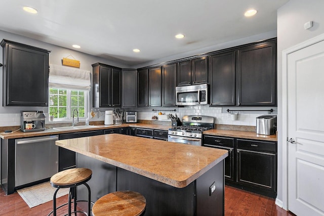 3512 Chancery Ln, Carpentersville, IL 60110 - kitchen with stainless steel appliances, a kitchen bar, dark wood-style flooring, tasteful backsplash, and recessed lighting