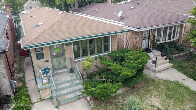 10240 S Torrence Ave, Chicago, IL 60617 - view of front of home featuring brick siding, a shingled roof, a chimney, and a porch