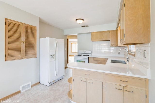 3671 Sarah St, Franklin Park, IL 60131 - kitchen featuring white appliances, a peninsula, light countertops, decorative backsplash, and light brown cabinetry