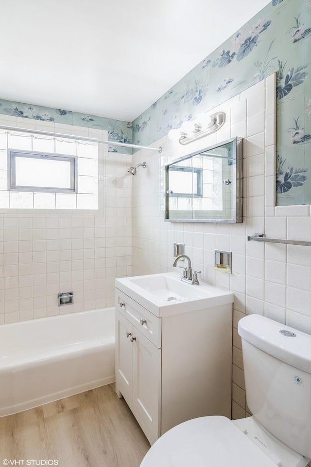 3671 Sarah St, Franklin Park, IL 60131 - bathroom with tile walls, vanity, wood finished floors, shower / tub combination, and wallpapered walls