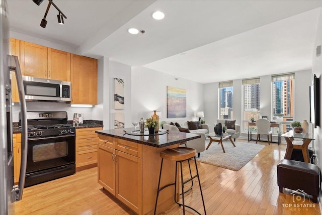1250 S Michigan Ave Unit 1007, Chicago, IL 60605 - kitchen featuring stainless steel appliances, a kitchen bar, open floor plan, light wood finished floors, and a center island