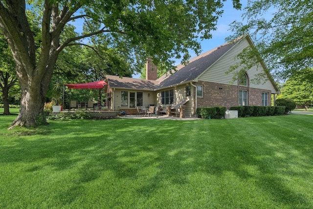 19466 W Aspen Dr, Mundelein, IL 60060 - rear view of property featuring a chimney, a lawn, a patio, and brick siding