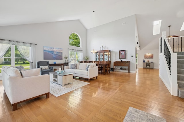 19466 W Aspen Dr, Mundelein, IL 60060 - living room featuring high vaulted ceiling, stairway, light wood-style floors, a skylight, and a chandelier
