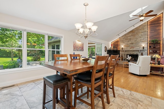 19466 W Aspen Dr, Mundelein, IL 60060 - dining space featuring a ceiling fan, a fireplace, lofted ceiling, and a chandelier