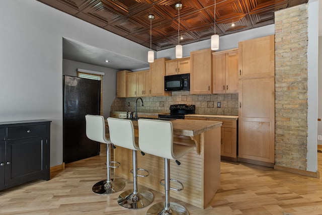 206 W N St, Leroy, IL 61752 - kitchen with black appliances, an ornate ceiling, decorative backsplash, light wood finished floors, and a center island with sink