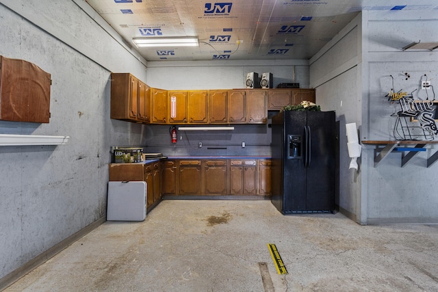 206 W N St, Leroy, IL 61752 - kitchen featuring black refrigerator with ice dispenser, brown cabinets, unfinished concrete floors, and dark countertops