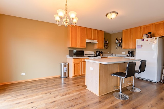 1077 Marcello Dr, Hampshire, IL 60140 - kitchen with white appliances, under cabinet range hood, light wood finished floors, and a kitchen island