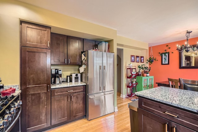 5404 N Hoyne Ave Unit 5404, Chicago, IL 60625 - kitchen with appliances with stainless steel finishes, light wood-style flooring, light stone counters, and dark brown cabinetry