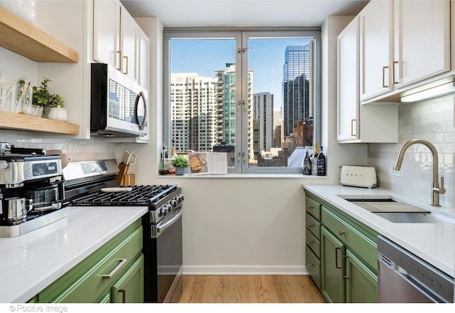600 N Dearborn St Unit 701, Chicago, IL 60654 - kitchen featuring green cabinets, appliances with stainless steel finishes, light wood-style flooring, and tasteful backsplash