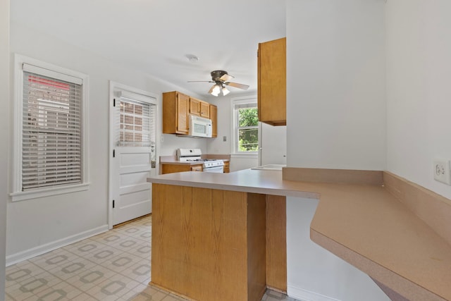 10410 S Walden Pkwy Unit 2N, Chicago, IL 60643 - kitchen with white appliances, a peninsula, light countertops, ceiling fan, and brown cabinetry