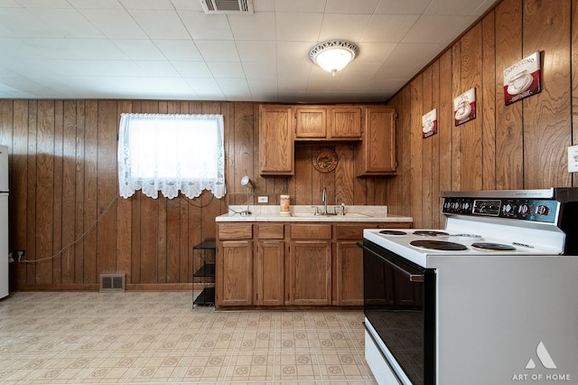 5444 S Kedvale Ave, Chicago, IL 60632 - kitchen featuring white electric stove, brown cabinetry, light countertops, wooden walls, and light floors