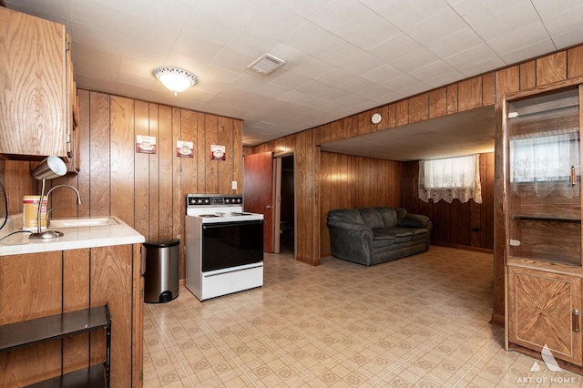5444 S Kedvale Ave, Chicago, IL 60632 - kitchen with white electric range, wooden walls, light countertops, brown cabinetry, and open floor plan