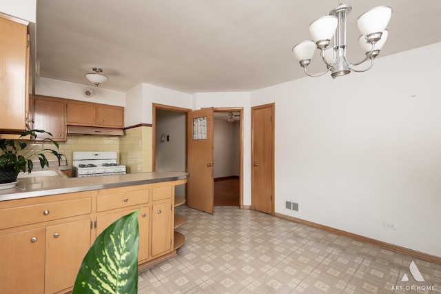 5444 S Kedvale Ave, Chicago, IL 60632 - kitchen with gas range gas stove, under cabinet range hood, backsplash, a chandelier, and light floors