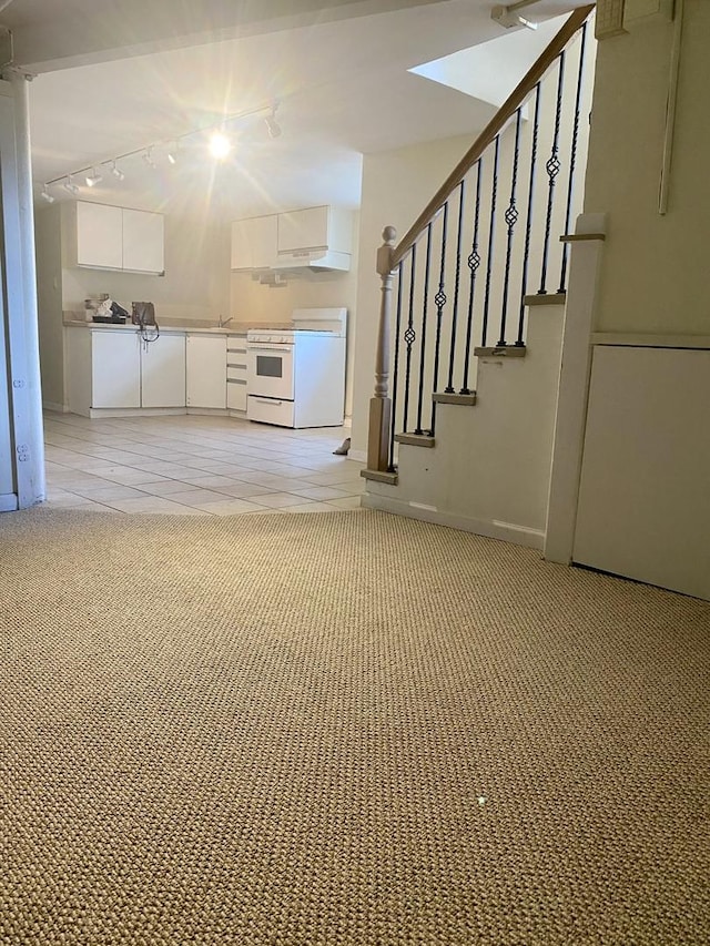 2614 W Lunt Ave, Chicago, IL 60645 - unfurnished living room featuring track lighting, light carpet, and stairs
