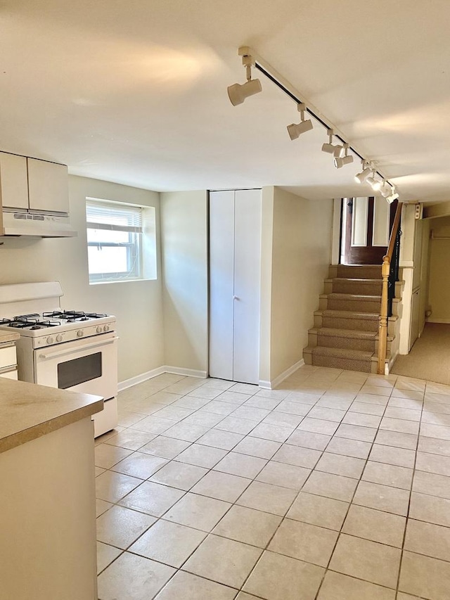2614 W Lunt Ave, Chicago, IL 60645 - kitchen featuring white gas range oven, track lighting, under cabinet range hood, white cabinets, and light countertops