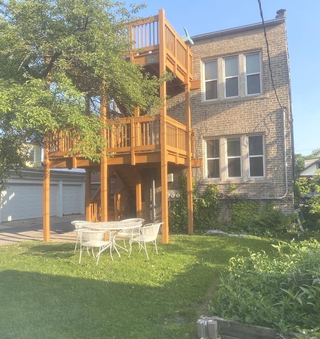 2614 W Lunt Ave, Chicago, IL 60645 - back of house featuring a yard, a garage, a deck, and brick siding