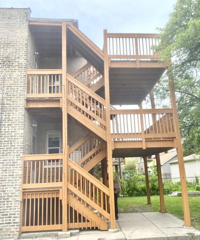 2614 W Lunt Ave, Chicago, IL 60645 - view of side of home with stairway, brick siding, and a wooden deck