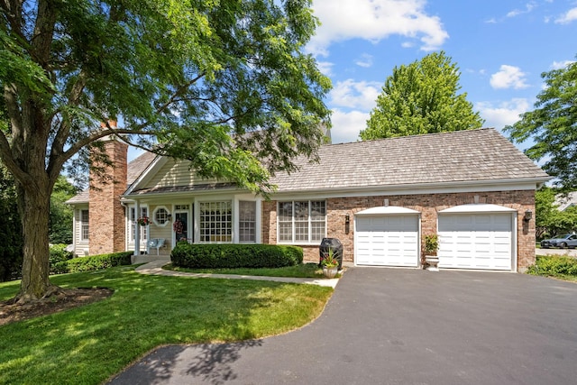 572 Stockbridge Ct, Lake Forest, IL 60045 - view of front of property featuring asphalt driveway, a garage, a chimney, a front yard, and brick siding