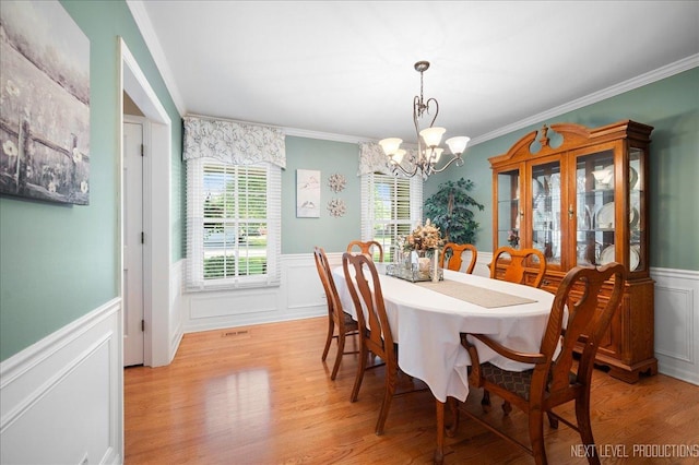1200 Crestview Dr, Batavia, IL 60510 - dining room with wainscoting, a chandelier, a decorative wall, crown molding, and light wood-style floors