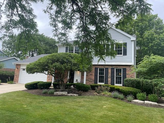 10S305 Havens Dr, Downers Grove, IL 60516 - view of front facade with brick siding, concrete driveway, a front yard, and a garage