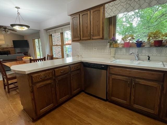 10S305 Havens Dr, Downers Grove, IL 60516 - kitchen with stainless steel dishwasher, a peninsula, light wood-style flooring, light countertops, and tasteful backsplash