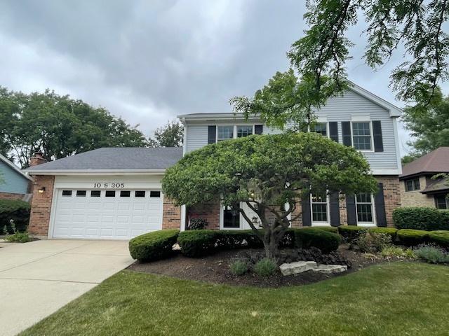 10S305 Havens Dr, Downers Grove, IL 60516 - view of front of home with brick siding, driveway, a garage, and a front lawn