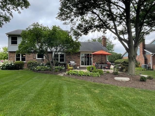 10S305 Havens Dr, Downers Grove, IL 60516 - back of house featuring brick siding, a yard, a chimney, and a patio