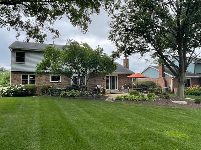 10S305 Havens Dr, Downers Grove, IL 60516 - rear view of property with a yard, brick siding, a chimney, and a patio