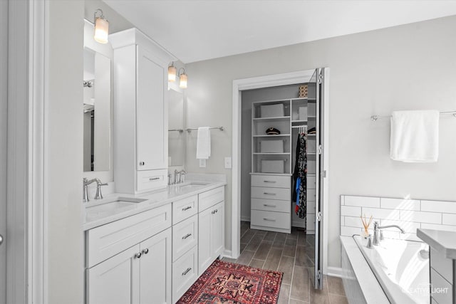 39W183 E Burnham Ln, Geneva, IL 60134 - bathroom featuring double vanity, a garden tub, a walk in closet, and wood finished floors