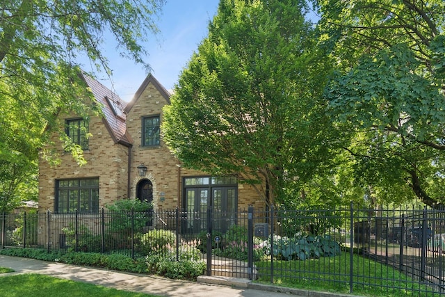 3045 W Ardmore Ave, Chicago, IL 60659 - tudor home with a fenced front yard, brick siding, and french doors