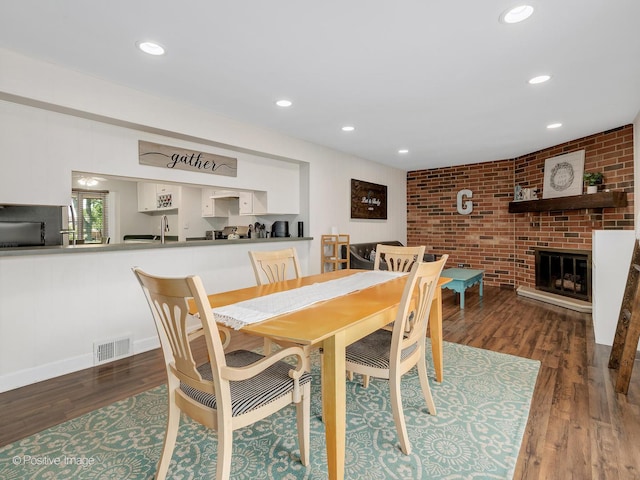 8228 W 140th St Unit 8228, Orland Park, IL 60462 - dining space featuring wood finished floors, a brick fireplace, recessed lighting, and brick wall
