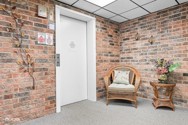 1423 Woodbridge Rd Unit 2C, Joliet, IL 60436 - living area featuring carpet, brick wall, and a drop ceiling
