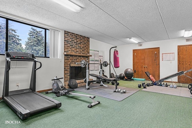 1423 Woodbridge Rd Unit 2C, Joliet, IL 60436 - workout room with carpet flooring, a fireplace, and a textured ceiling