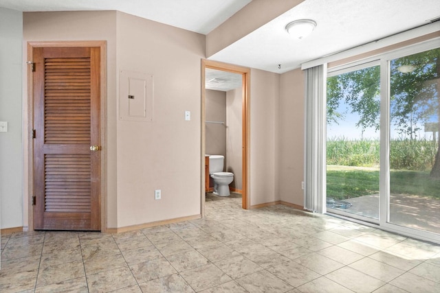 23 Fetzer Dr Unit 3, Bloomington, IL 61704 - unfurnished bedroom featuring electric panel, access to outside, ensuite bath, and light tile patterned flooring