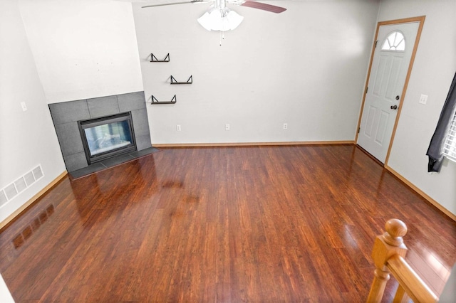 23 Fetzer Dr Unit 3, Bloomington, IL 61704 - unfurnished living room featuring a tiled fireplace, wood finished floors, and ceiling fan